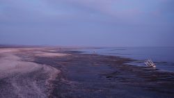 A view of a beach with various pieces of trash on it.