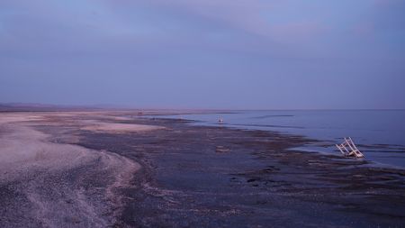 A view of a beach with various pieces of trash on it.