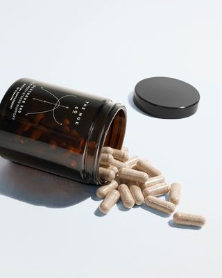 The Nu Co Destress 360 capsules in brown bottle on white background