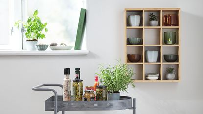 Wall shelf TOLNE 12 shelves bamboo and trolley in dining room