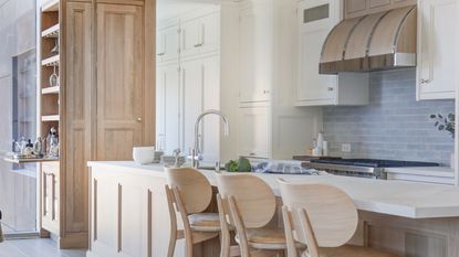 A light wood kitchen with white countertops and large kitchen island