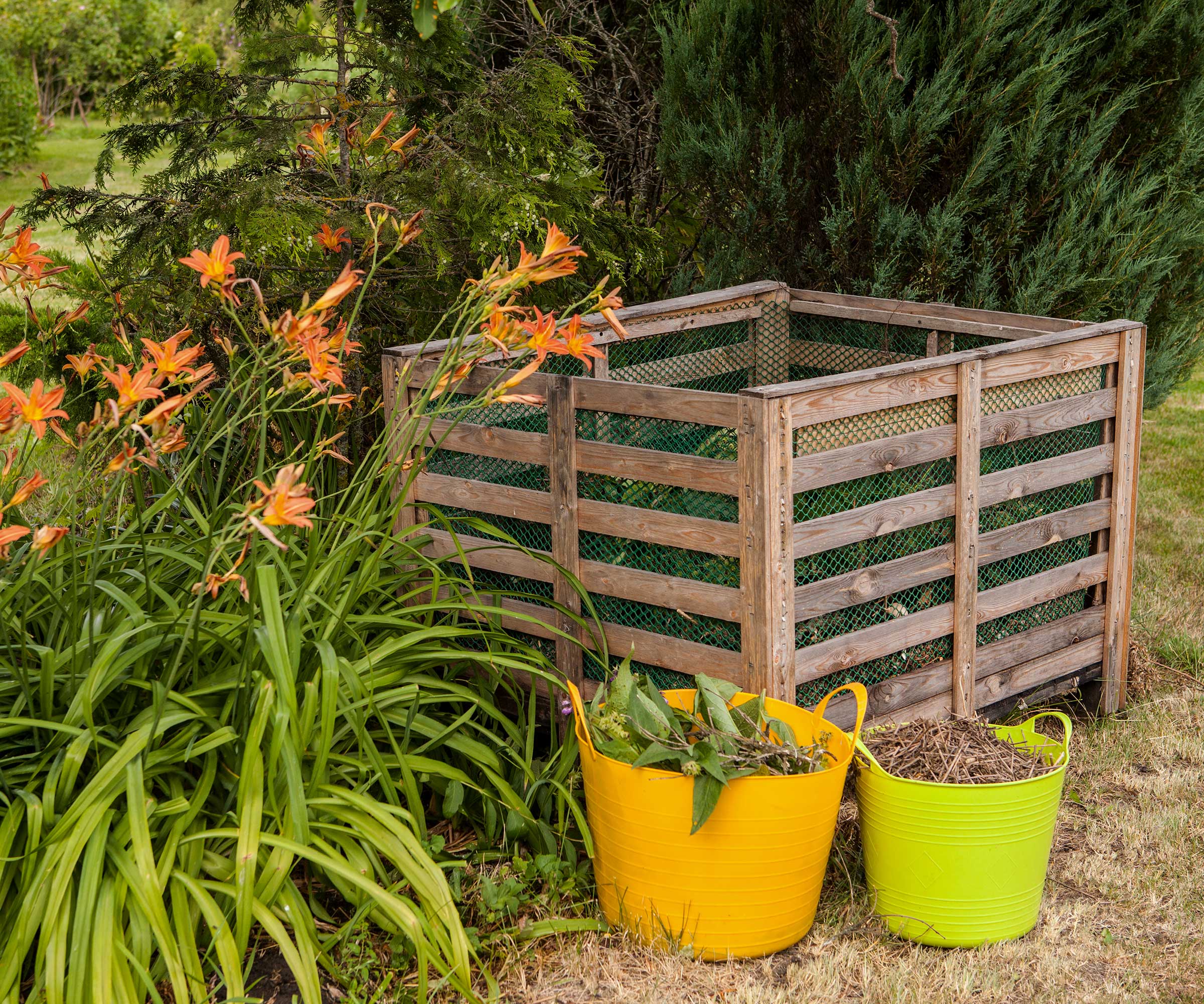 compost bins in a garden with colorful buckets