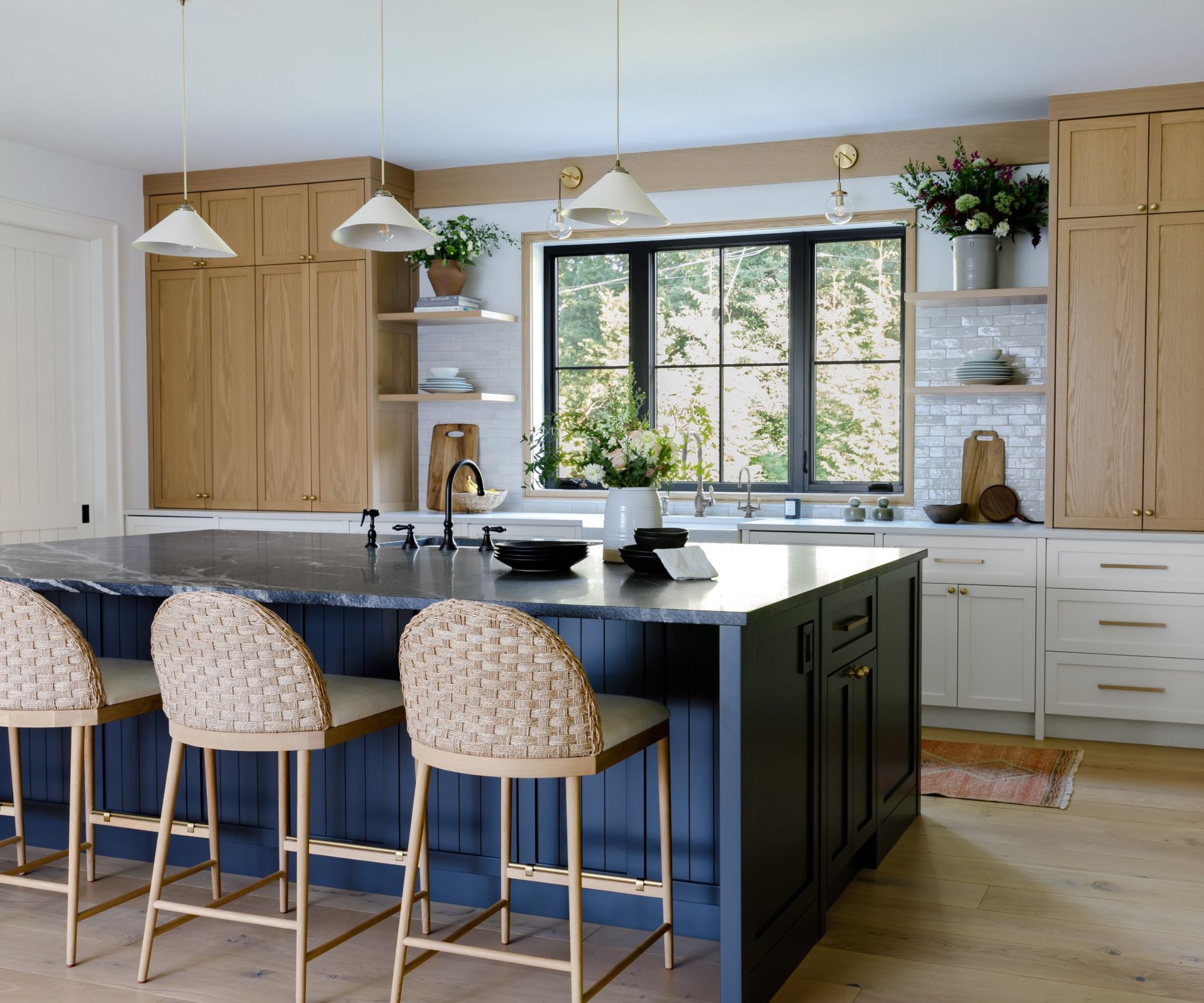 A blue, white, and wood kitchen with a granite countertops used on the island