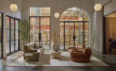 A glass-box-like design showroom with plush leathery and marble furniture.