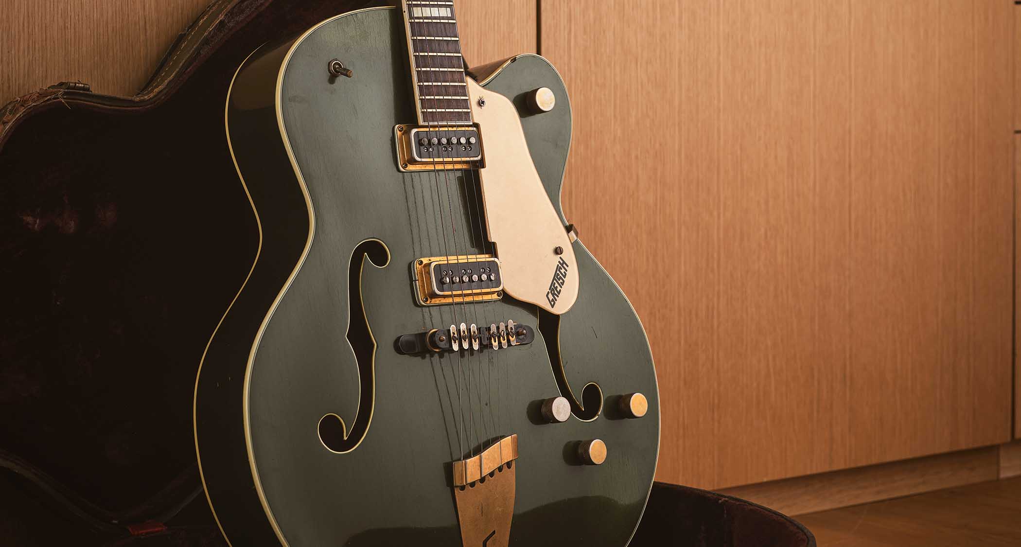 A green Gretsch hollowbody electric photographed in its case