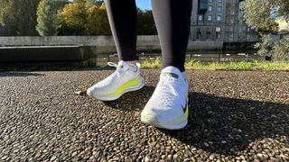 Woman's feet wearing Nike Infinity Run Flyknit 4 road running shoes - front view