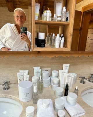 Dr Barbara Sturm taking a mirror selfie in her bathroom with Dr Barbara Sturm products