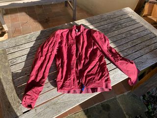 Maap Flow Insulated purple cycling jacket on a wooden table