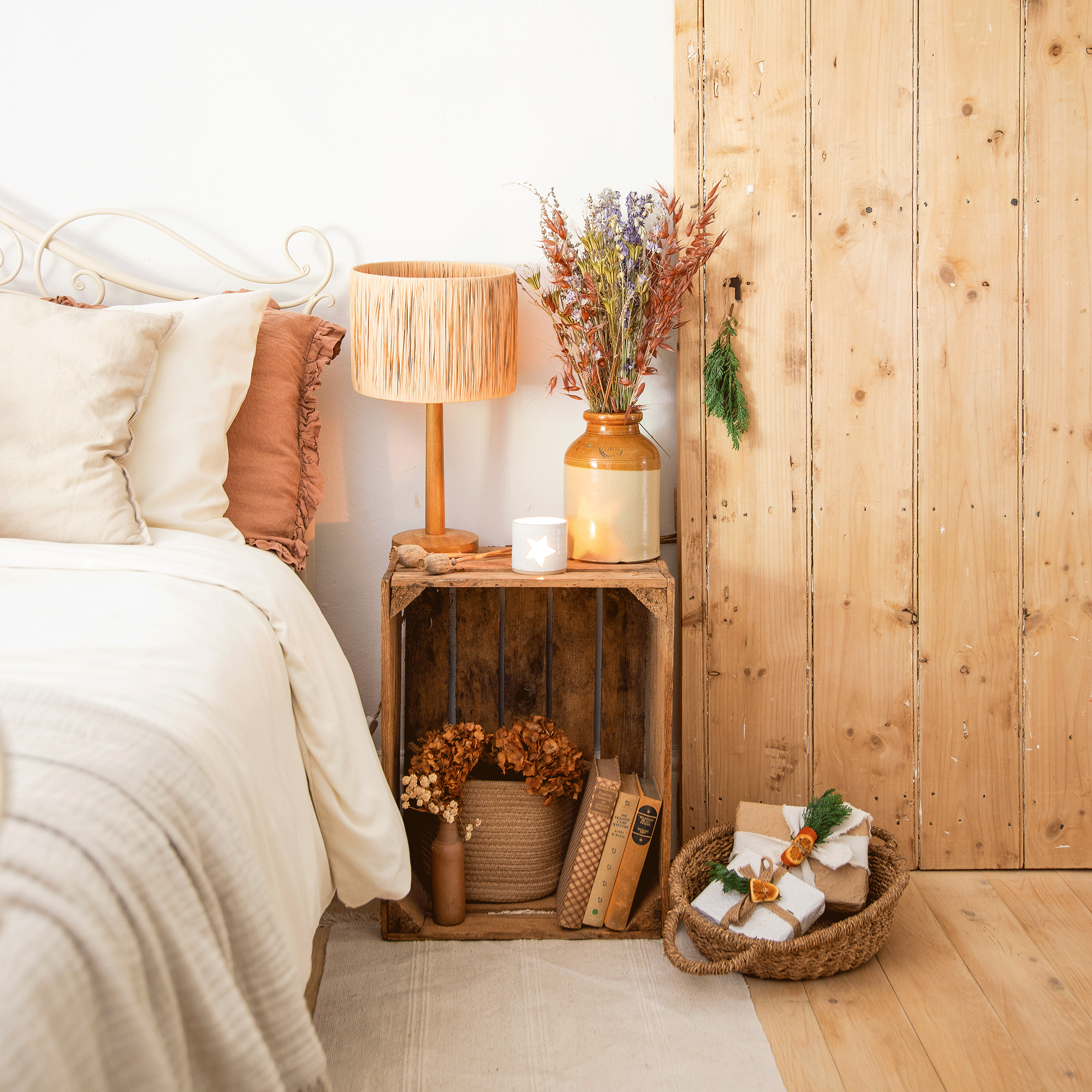 a bedroom with a bedside table made from a crate and a lamp with a raffia lampshade