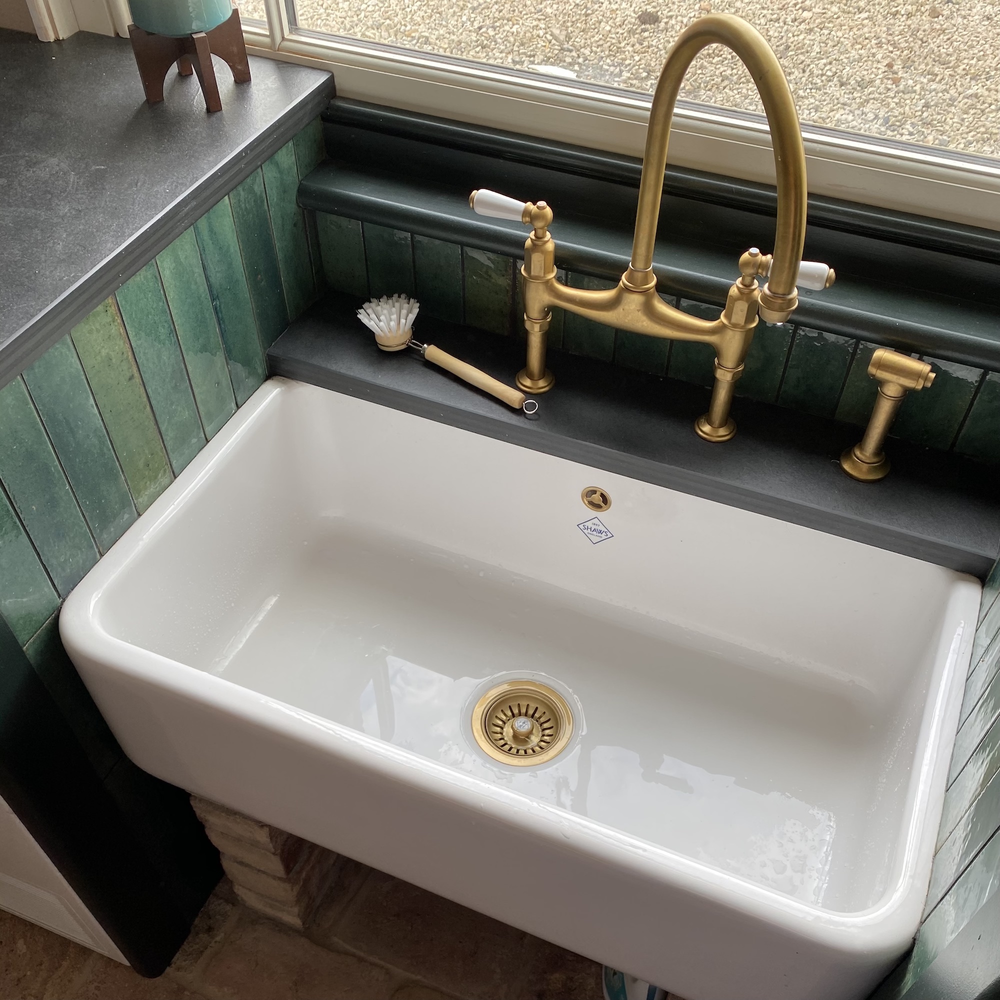 large sink on bricks and brass taps
