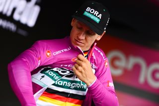 Pascal Ackermann (Bora-Hansgrohe) gingerly puts on the Giro's maglia ciclamino after crashing in the stage 10 sprint