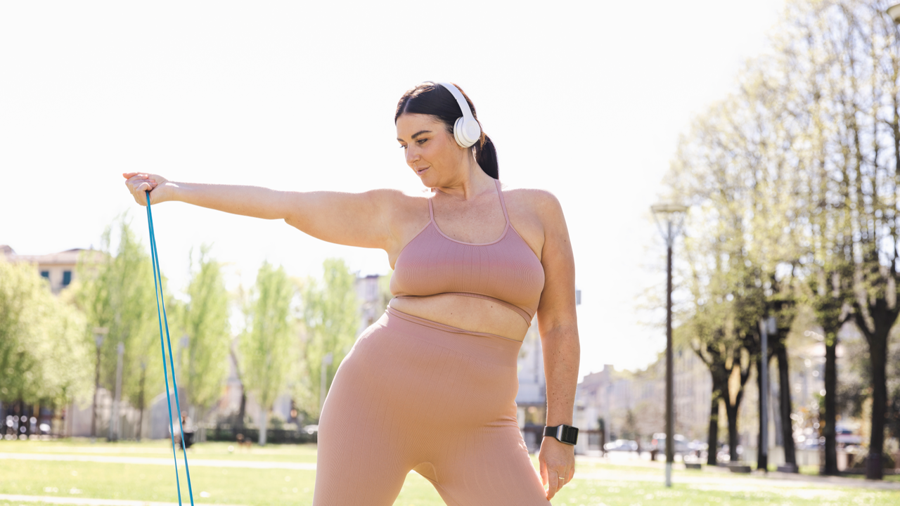 Woman doing a resistance band workout in the park