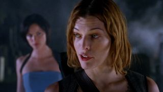 Milla Jovovich talks over her shoulder to Sienna Guillory in Resident Evil: Apocalypse.
