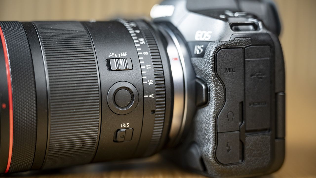 Close up of the Canon RF 35mm F1.4 lens on a wooden table, attached to a Canon EOS R5