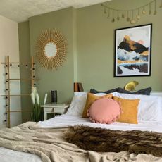 Double bed in a a bedroom with green feature wall 