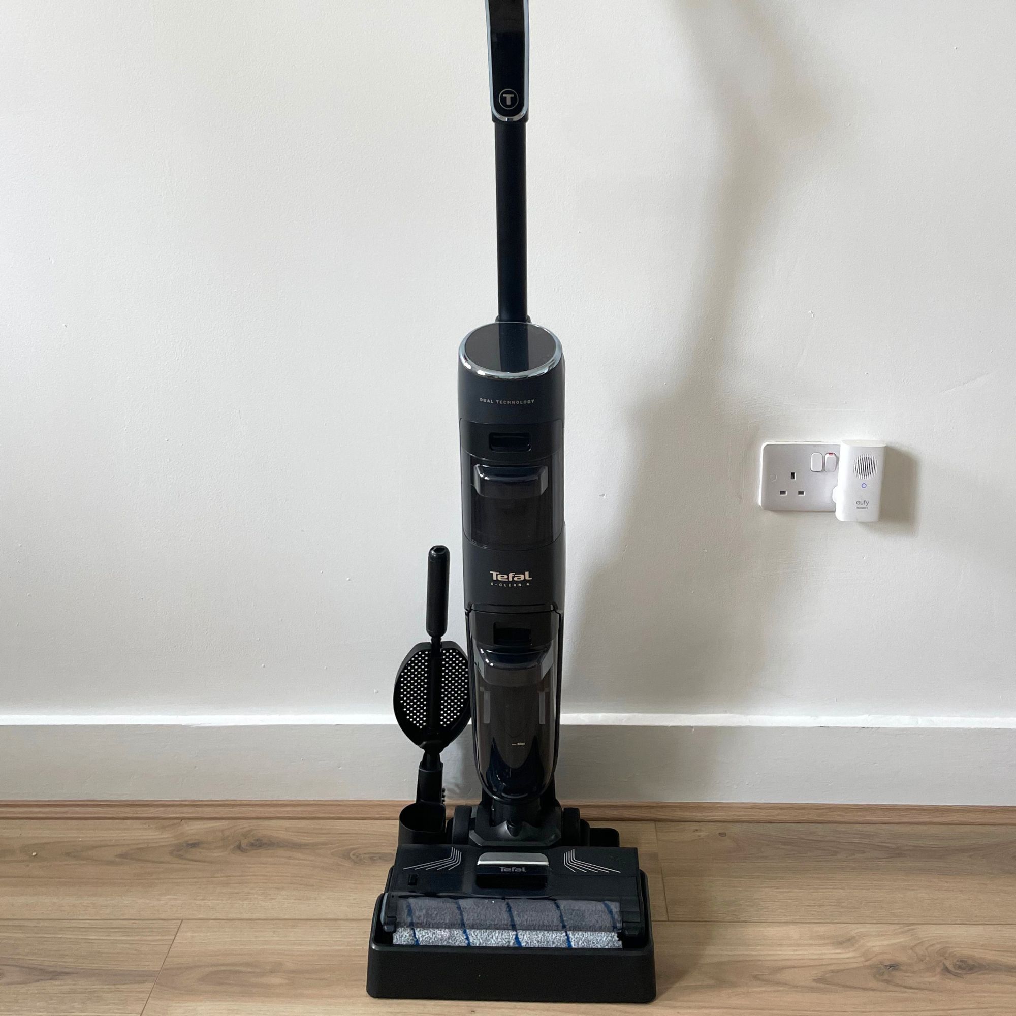 Tefal X-CLEAN 4 vacuum mop sitting on laminate floor against a white wall