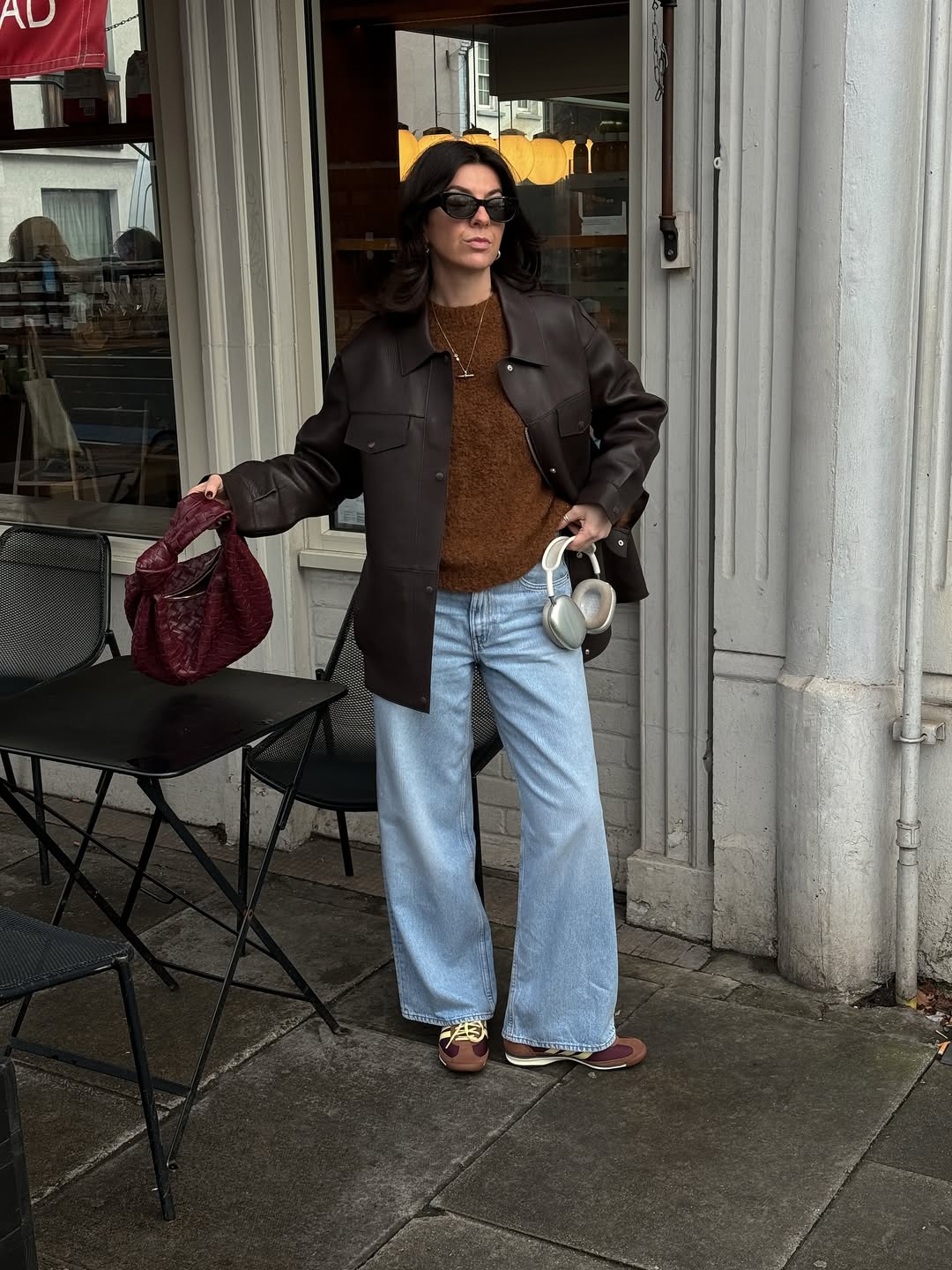 @francescasaffari wears blue jeans brown jumper leather jacket trainers
