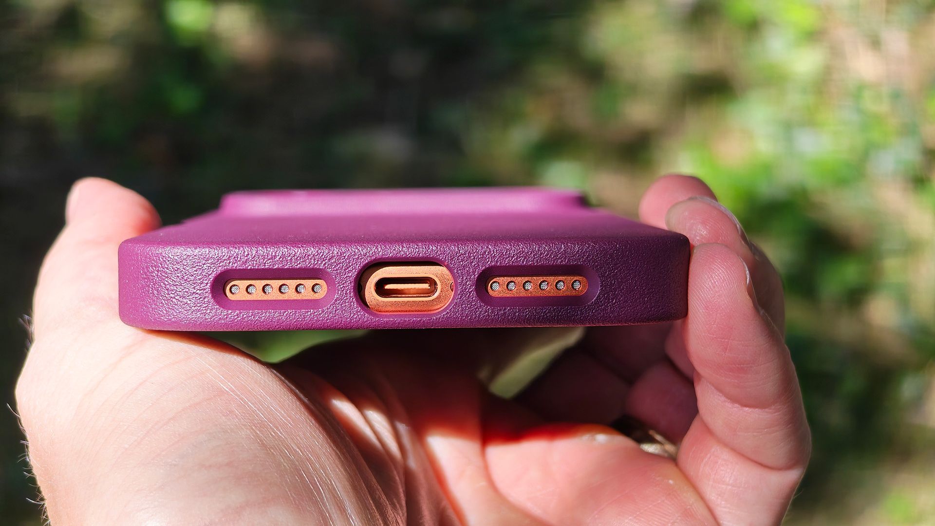 A burgundy Dbrand MNML case on an orange Apple iPhone 17 Pro Max