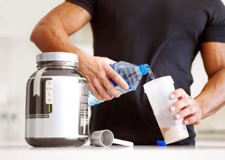 A man mixing water with protein powder in a protein shaker bottle