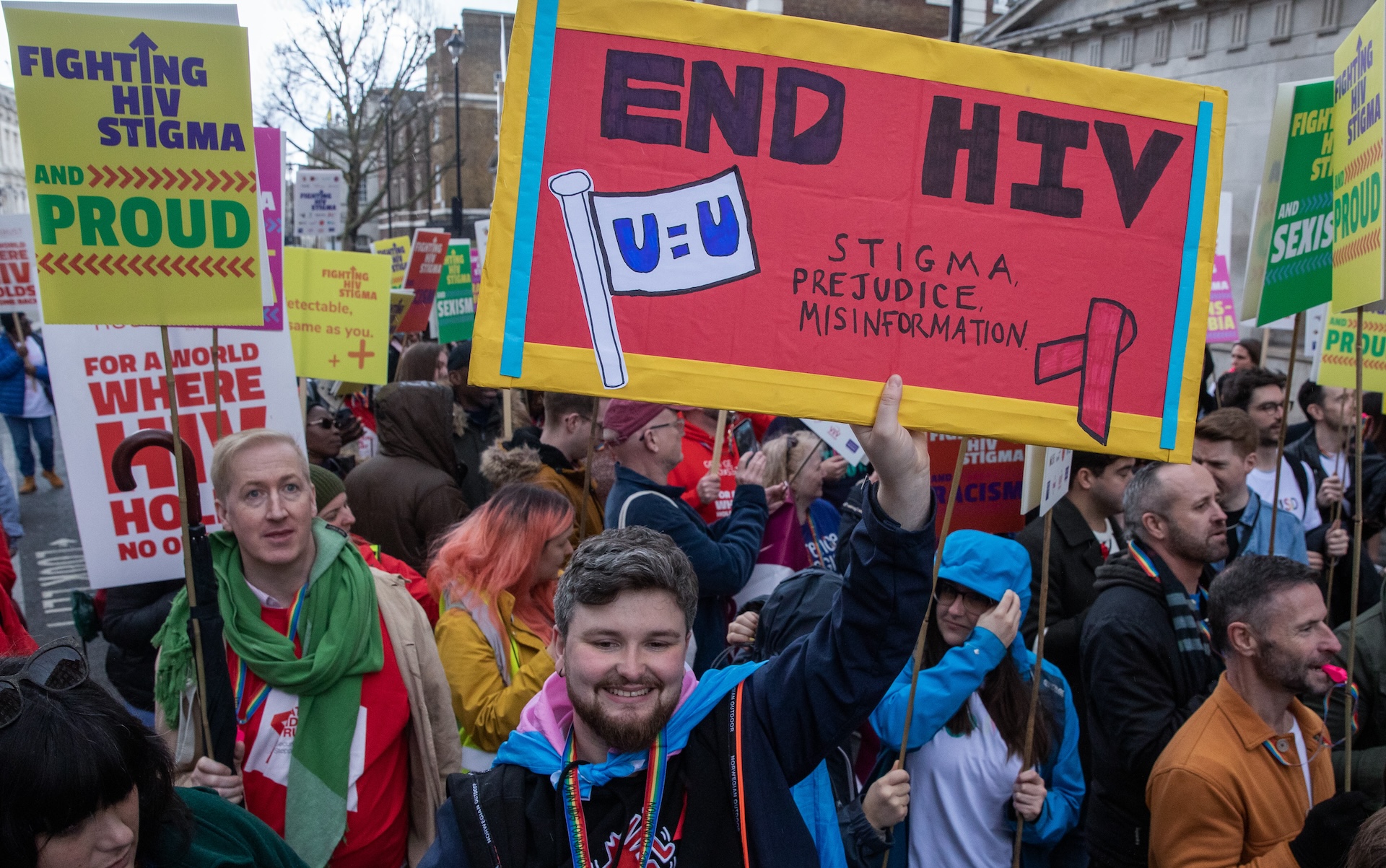 Protestors hold signs with messages about fighting HIV stigma during a march in London.