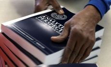 An employee stacks copies of President Obama's budget proposal for 2014 at the Government Printing Office on April 8.