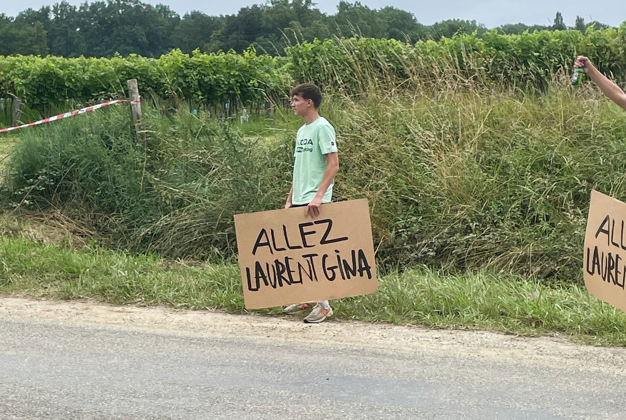 A fan at the Tour de France holding a sign that says Allez Laurent Gina