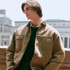 A man on a roof modelling a tan Carhaart jacket 