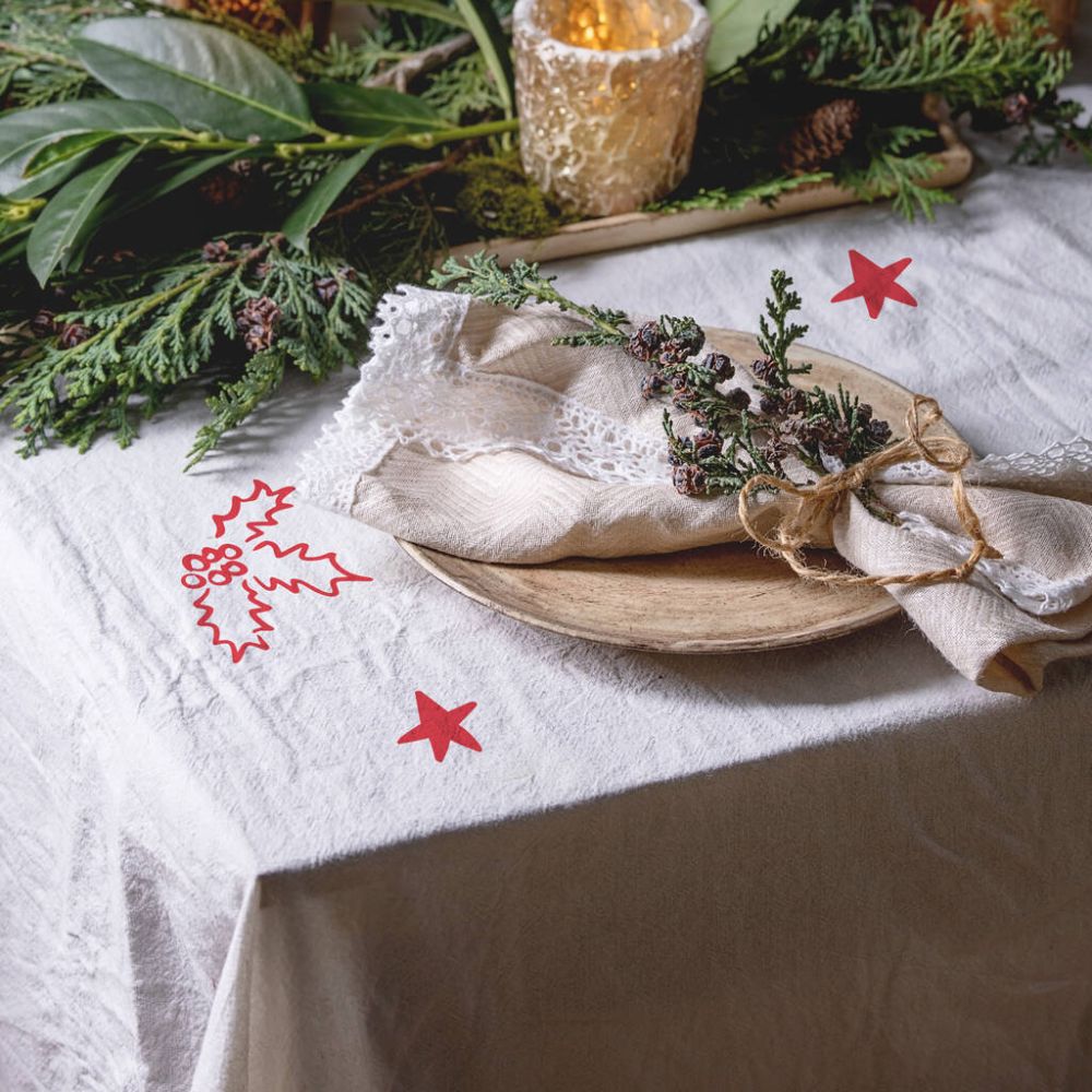 white tablecloth with red star and holly stickers