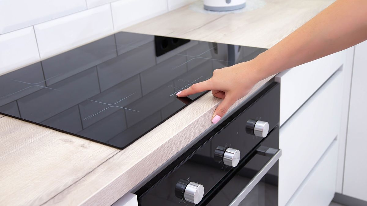 Woman setting the controls on an induction cooktop