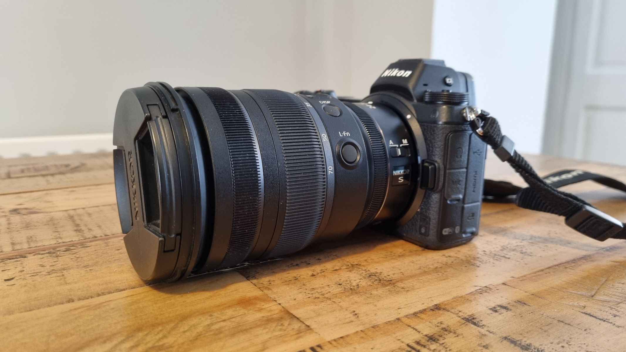 Productafbeelding van de lens op een houten tafel bevestigd aan een Nikon Z6