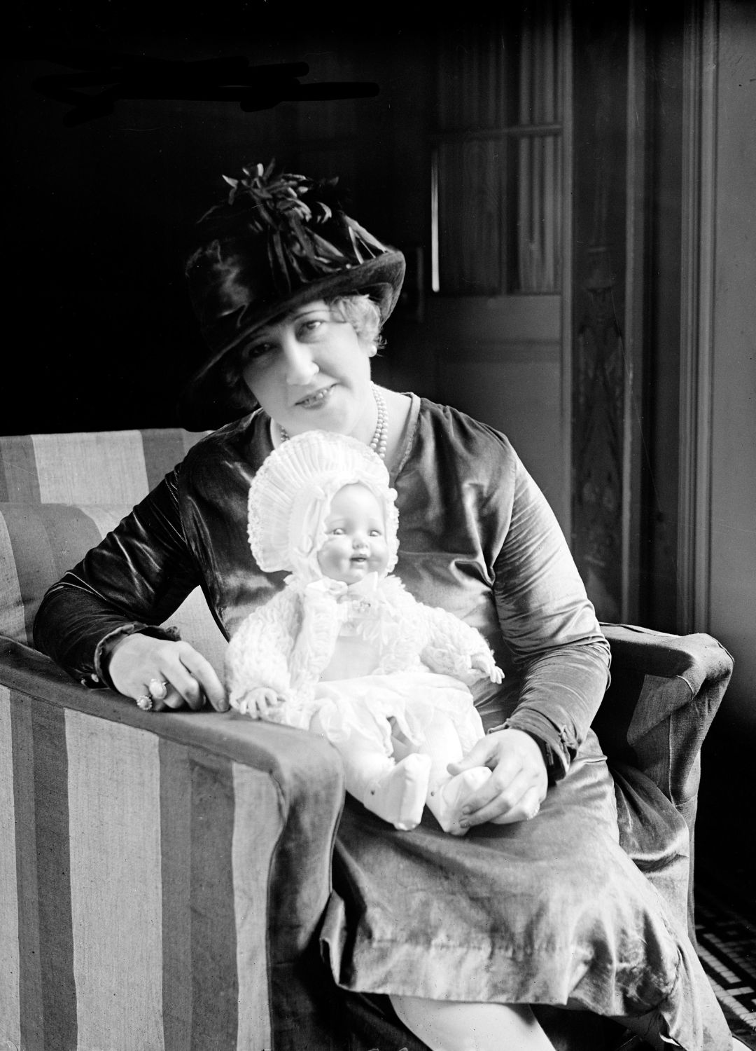 A black and white picture of Beulah Louise Henry holding a doll with moveable limbs which was one of her inventions
