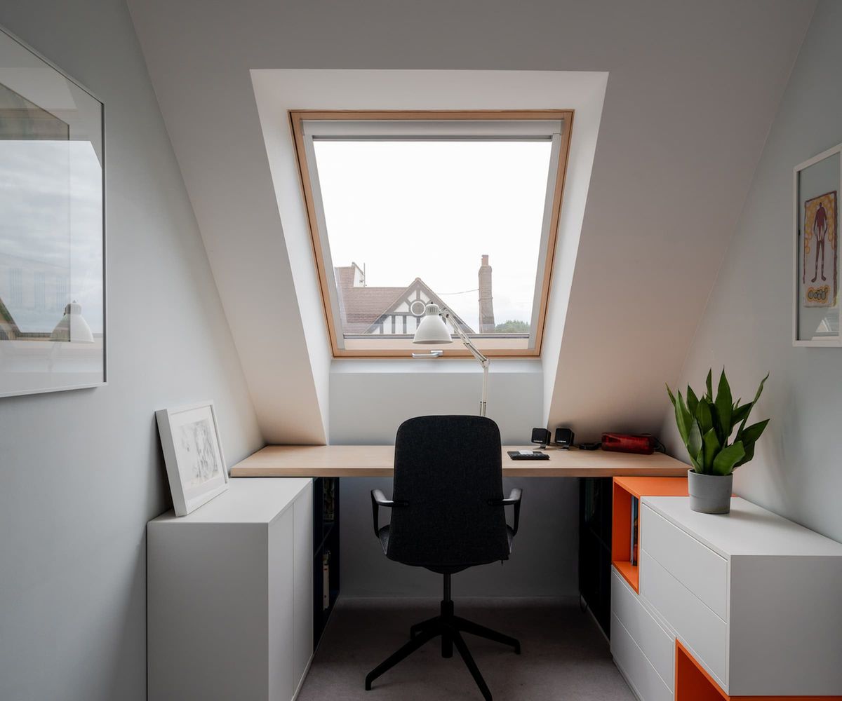 An upstairs office with vaulted ceiling and window