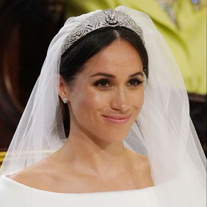 Meghan Markle smiling in a veil and tiara on her wedding day