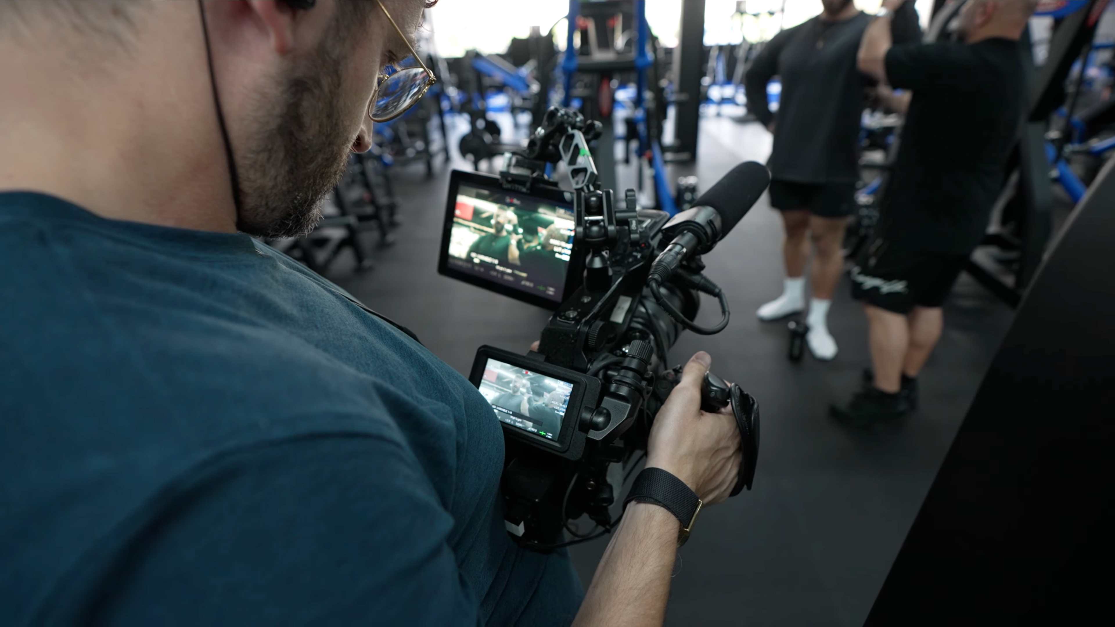 Over the shoulder shot of Mark Bone filming with the Sony FX6 in a gym