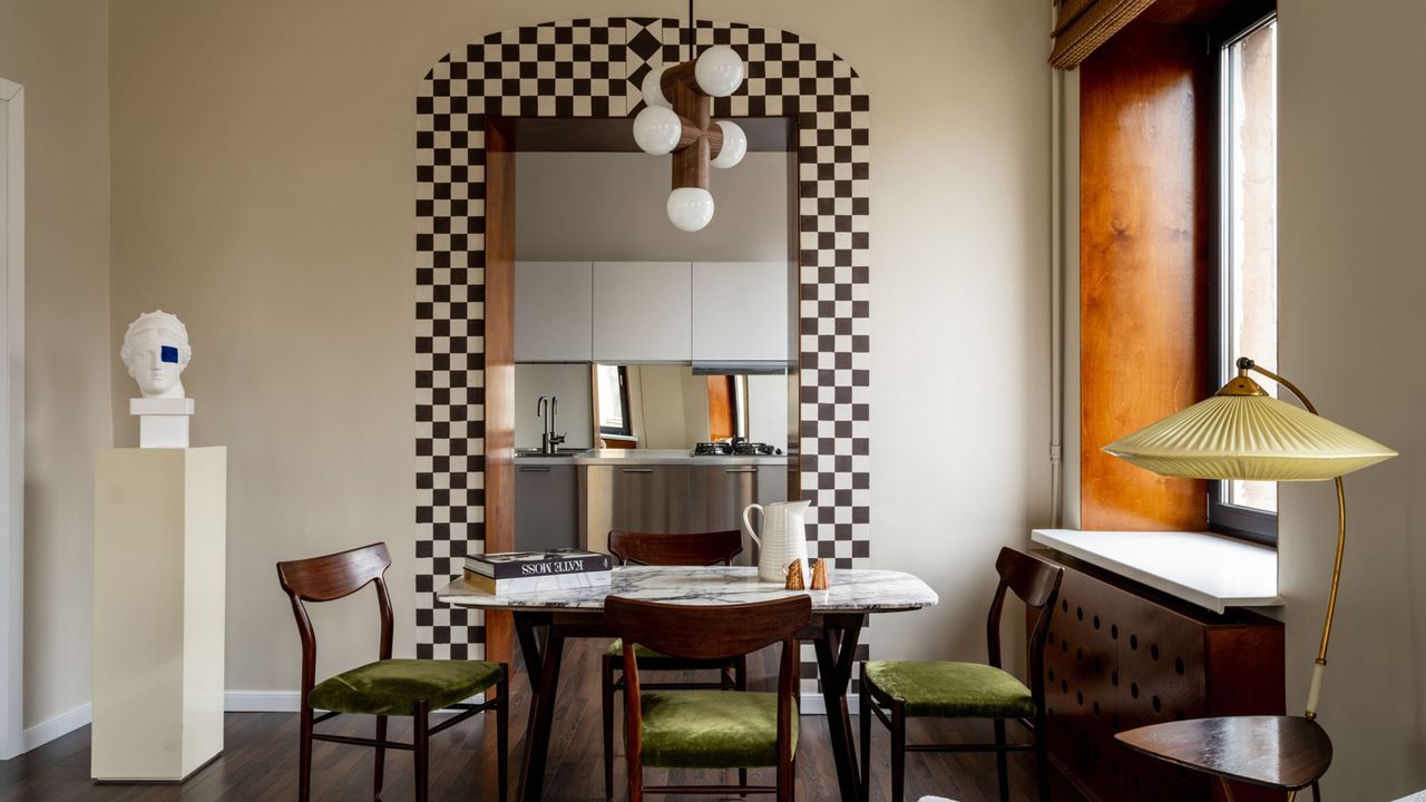 dining room with checkerboard print painted around doorway, marble table, with timber and velvet dining chairs, plinth with sculpture, and lamp