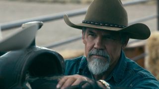 Josh Brolin as Royal Abbott wearing a cowboy hat, leaning against saddle.