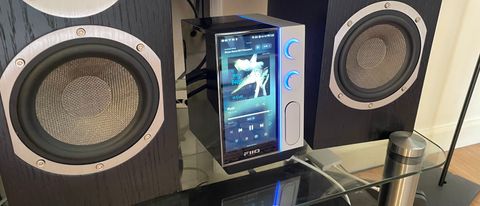 FiiO R9 on a hi-fi rack with active speakers either side