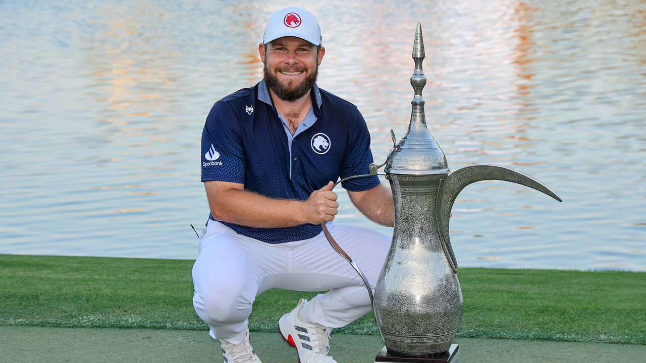 Tyrrell Hatton poses next to the 2025 Hero Dubai Desert Classic trophy