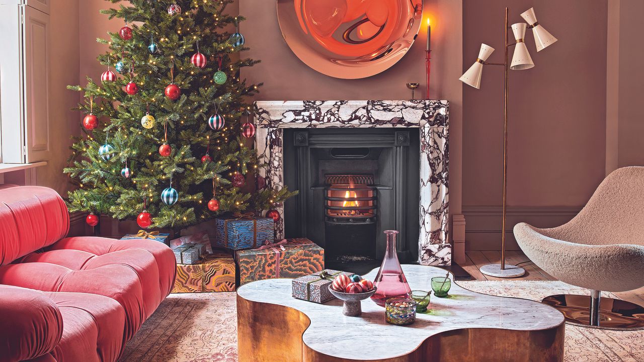 Living room with red sofa, chritmas tree and marble fireplace