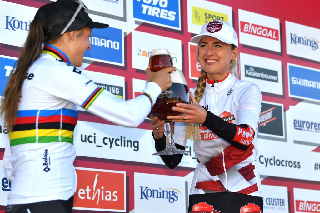 ZONHOVEN BELGIUM OCTOBER 24 LR Lucinda Brand of The Netherlands and Team Baloise Trek Lions on second place and race winner Denise Betsema of The Netherlands and Team Pauwels Sauzen Bingoal celebrate with a beer on the podium ceremony after the 25th Zonhoven UCI CycloCross Worldcup 2021 Womens Elite CXWorldCup UCIcyclocrossWC zonhoven on October 24 2021 in Zonhoven Belgium Photo by Luc ClaessenGetty Images