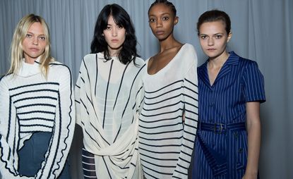 Models wear striped knit, blouse, dress and coat in black, white and blue