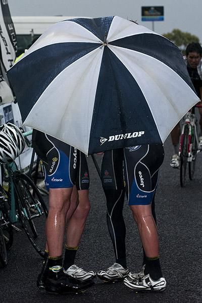 Keeping skins dry: Team Jayco Skins riders huddle beneath an umbrella when rain soaked the tour presentations in Geelong.