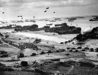 Landing ships putting cargo ashore on Omaha Beach, at low tide during the first days of the operation, mid-June, 1944, of the Invasion of Normandy.
