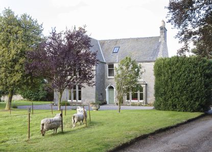 exterior of a georgian home with sheep in the foreground