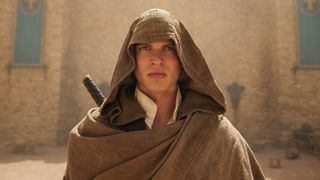 A hooded Rand looks up at something off screen in The Wheel of Time season 2