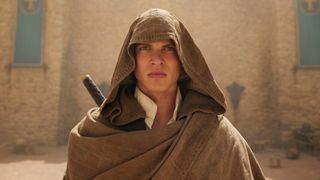 A hooded Rand looks at something off screen in The Wheel of Time season 2