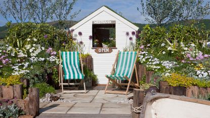 striped deckchairs and white shed in garden