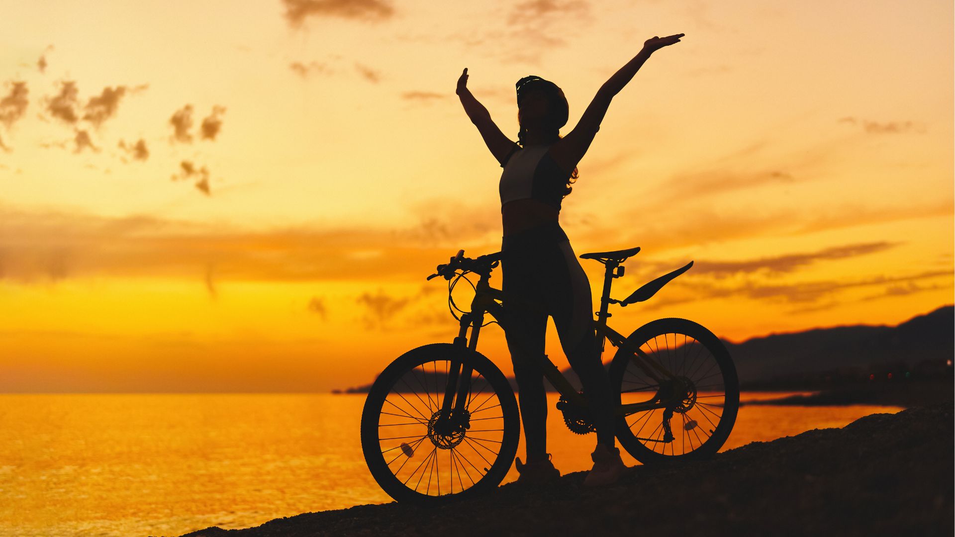 Woman cycling at sunset