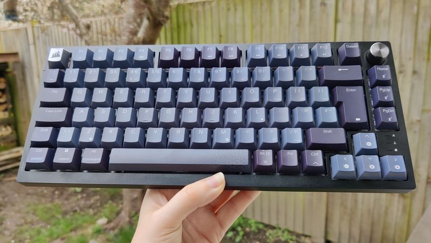 Corsair K65 pictured outdoors with black and grey keycaps.