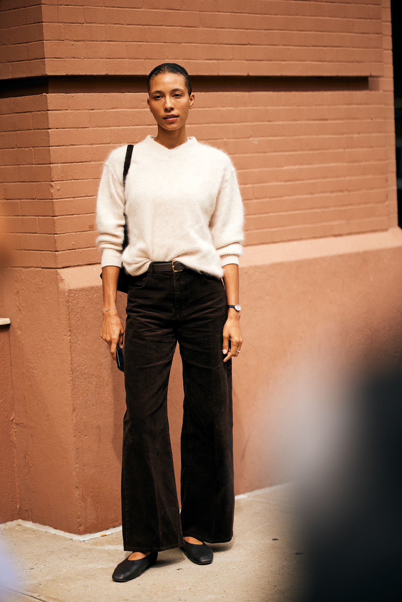 Woman in high V-neck sweater and pants.